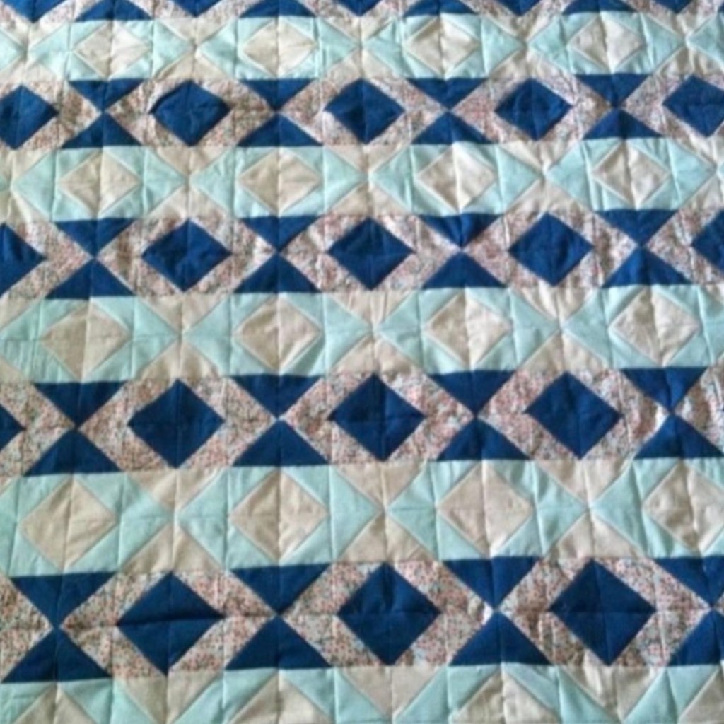 Quilt with diamonds and stripes in aqua, teal, and light grey