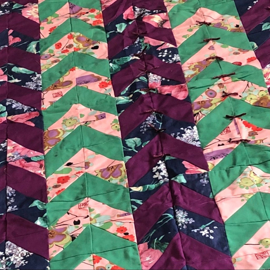 Quilt with chevrons in maroon, green, navy, and peach